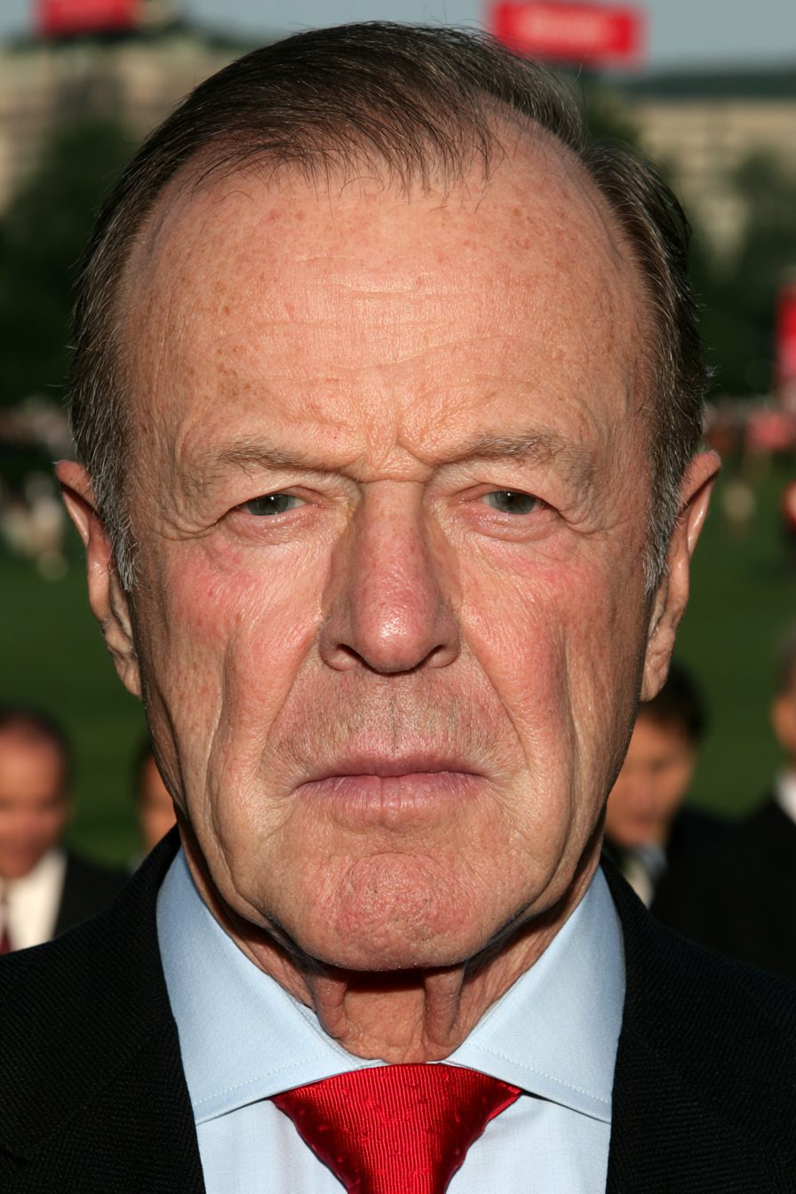 Gordon Fisk in a dark suit and red tie